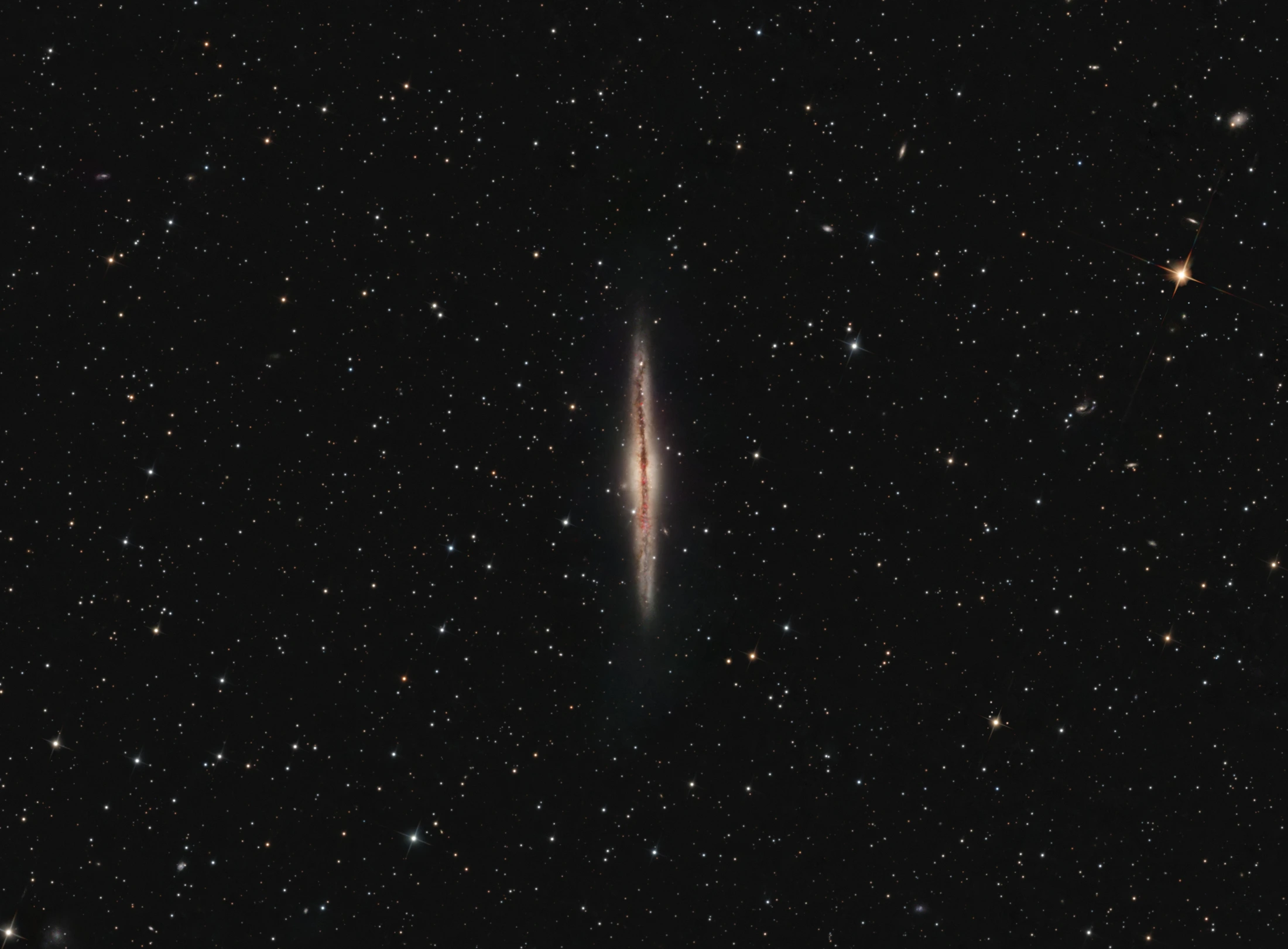 NGC 891 surrounded by stars: a thin edge-on spiral galaxy with a dark dust lane and red emission regions